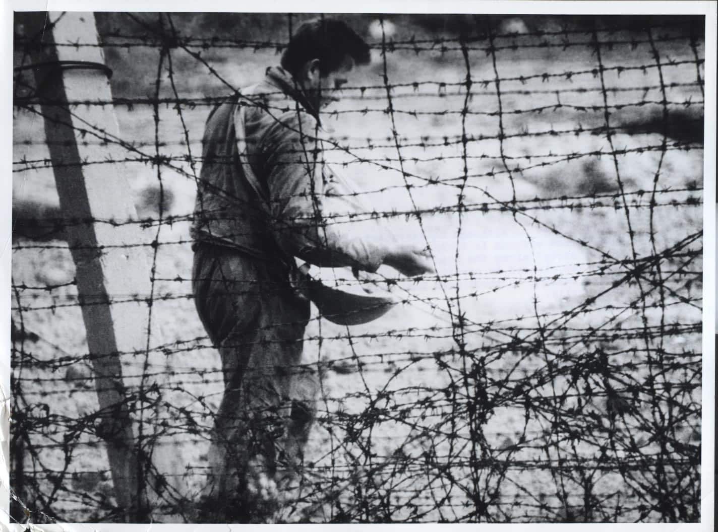 A worker spreads chemicals to kill weeds and to provide a clear line of fire for the East German guards watching the border for anyone seeking to escape to West Berlin. Late August 1961. From the CIA booklet "A City Torn Apart: Building of the Berlin Wall."