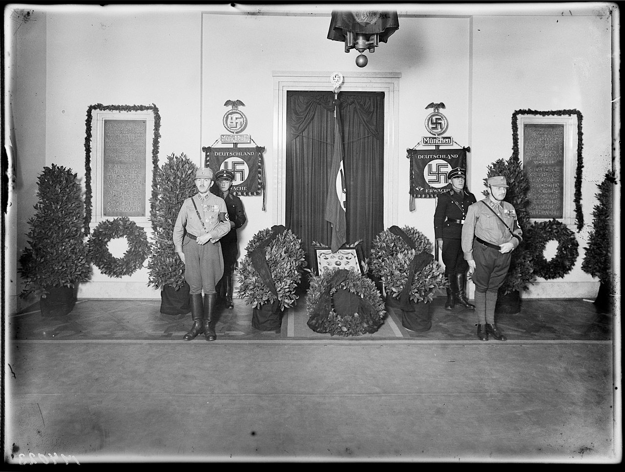 Honour guard at the Brown House in Munich (in front of the entrance to the Senate Hall, vestibule, first floor), around 1932–1934, protecting the Blood Flag - Public Domain