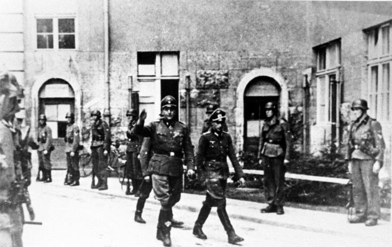 Waffen-SS soldiers in Bendlerstrasse (Bendlerblock), two officers walking through a line of soldiers (July 20th 1944) - German Federal Archives, Image 146-1972-109-18A / CC-BY-SA 3.0