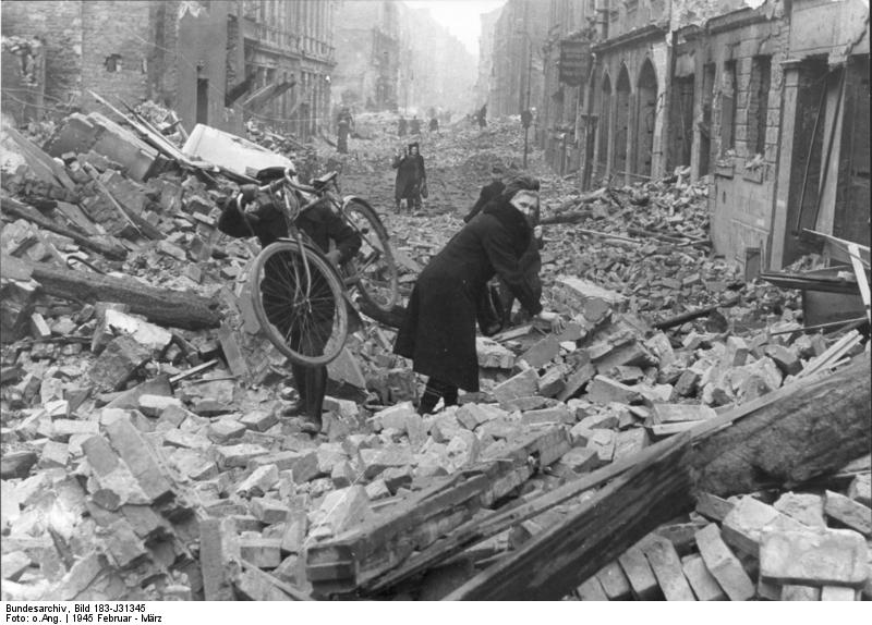Berliners stumble through the rubble of the city following an Allied air attack in February 1945