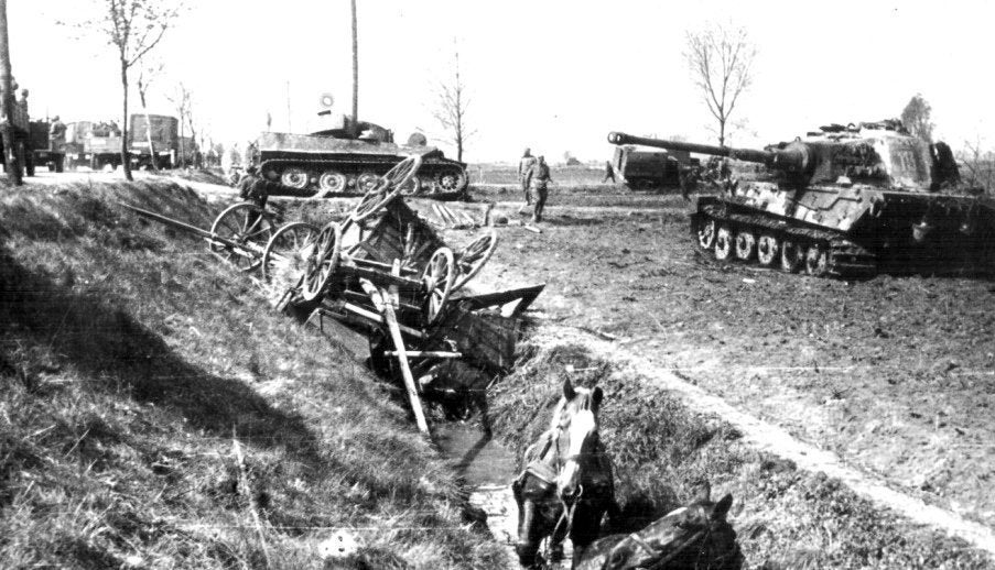 A Soviet convoy passes a destroyed German Tiger I and a Tiger II tank at Seelow Heights, 1945