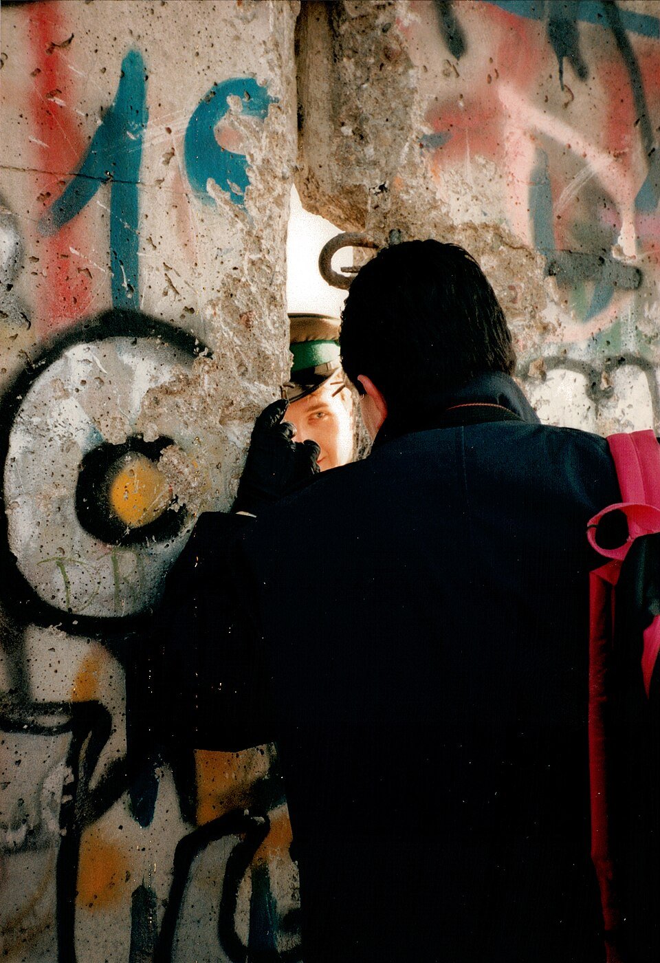 An East German guard speaks to a Westerner through a broken seam in the Berlin Wall, November 1989 - Creative Commons Attribution-Share Alike 3.0 Unported license
