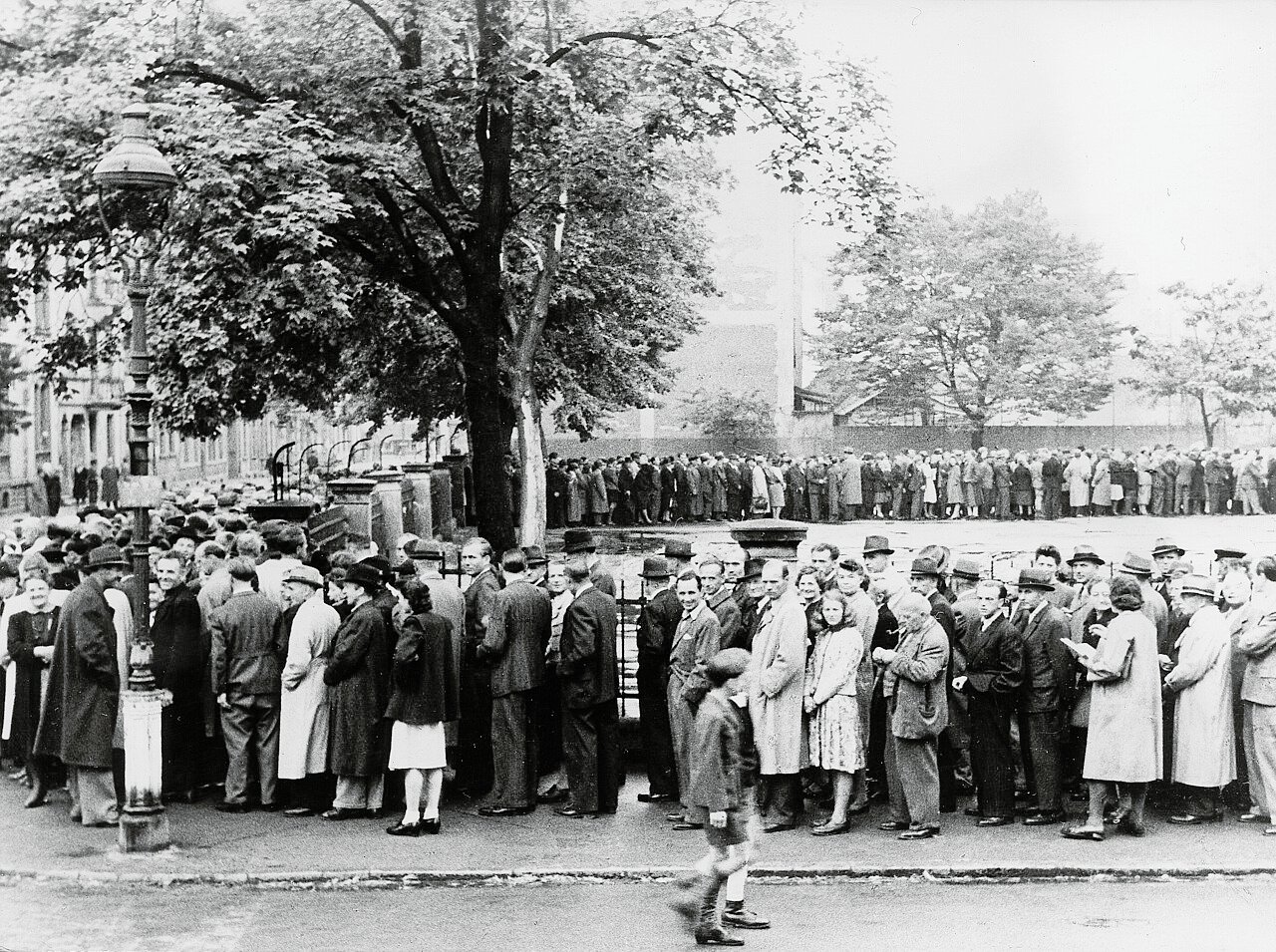 People in Frankfurt am Main queue in front of a currency exhange (June 1948) - Public Domain