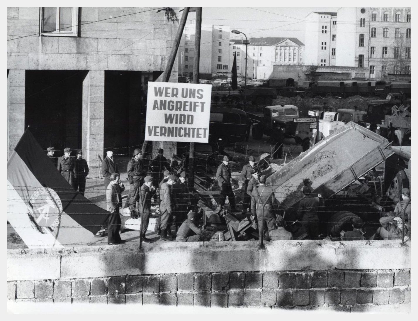 A sign at the Berlin Wall in East Berlin (November 1961) declares, “Whoever attacks us will be destroyed," - Public Domain