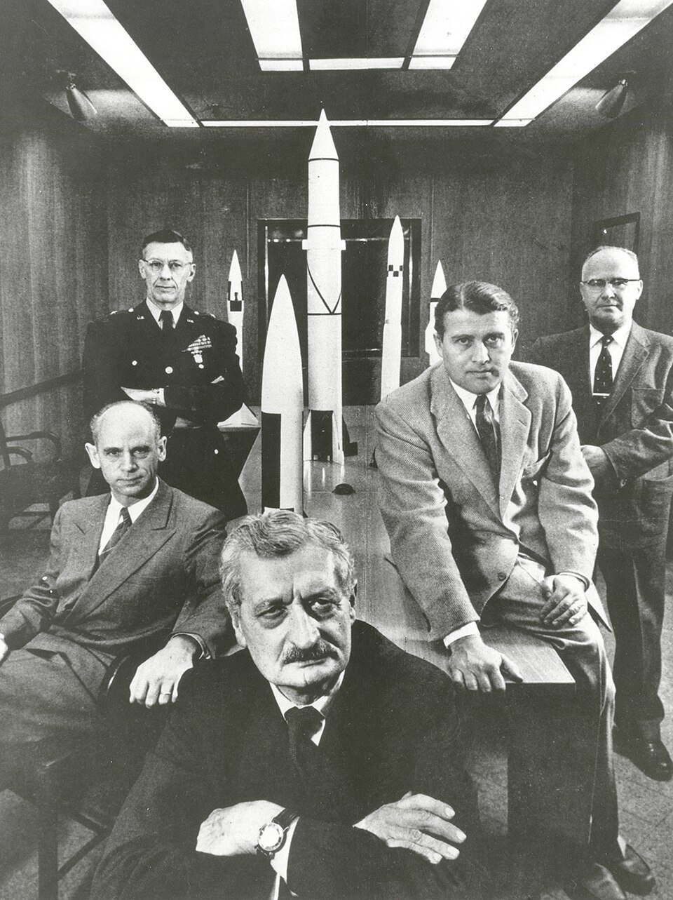 Officials of the US Army Ballistic Missile Agency (1956) - including Major General H.N. Toftoy (back left), responsible for Operation Paperclip, and Nazi rocket scientist, Werner von Braun (second from right) - Public Domain
