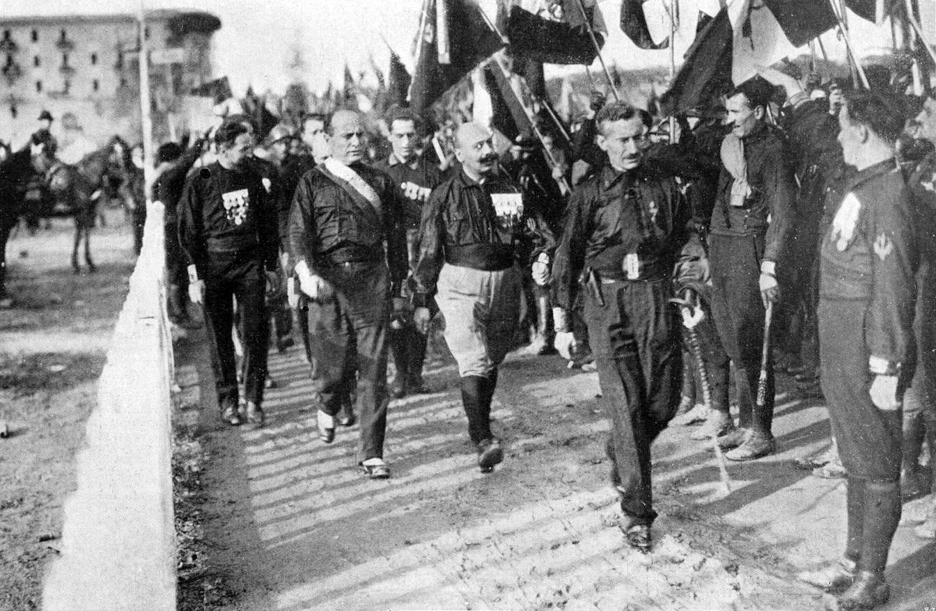 Benito Mussolini, Cesare Maria de Vecchi and Michele Bianchi receive the 'Roman Salute' in Naples in 1922 - Public Domain