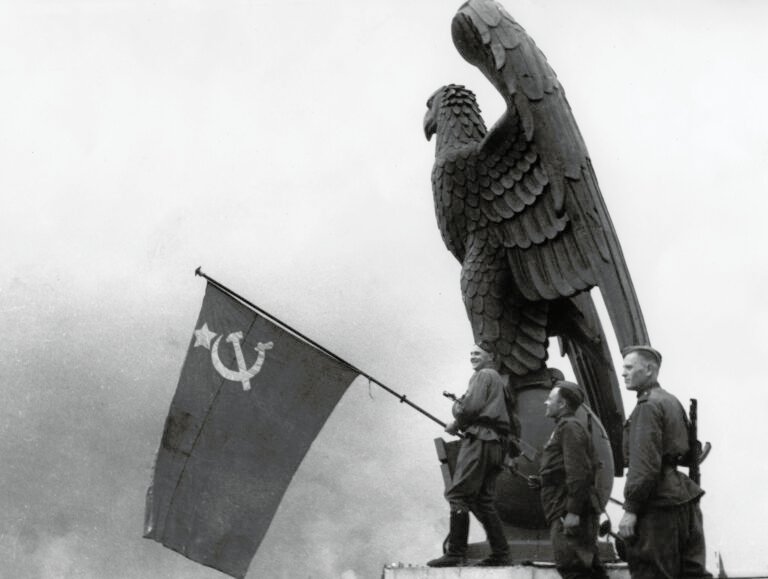 Soviet troops pose next to the Reichsadler as it once appeared on top of Tempelhof Airport (1934) - Public Domain
