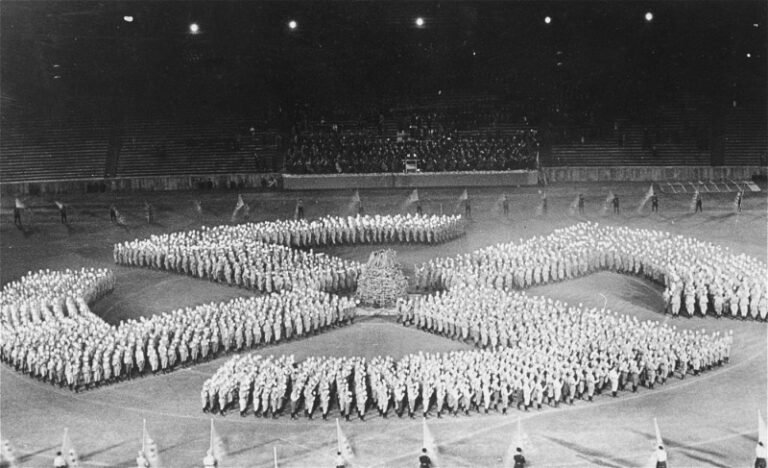 Members of the Hitler Youth parade in the formation of a swastika to honor the Unknown Soldier. Germany, August 27th 1933 - Public Domain