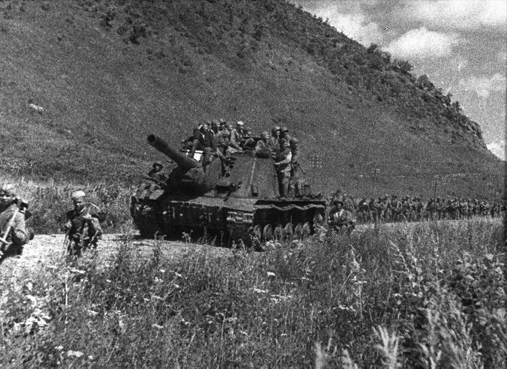 A Soviet ISU-152 self-propelled gun and infantry during a march in Manchuria - Public Domain